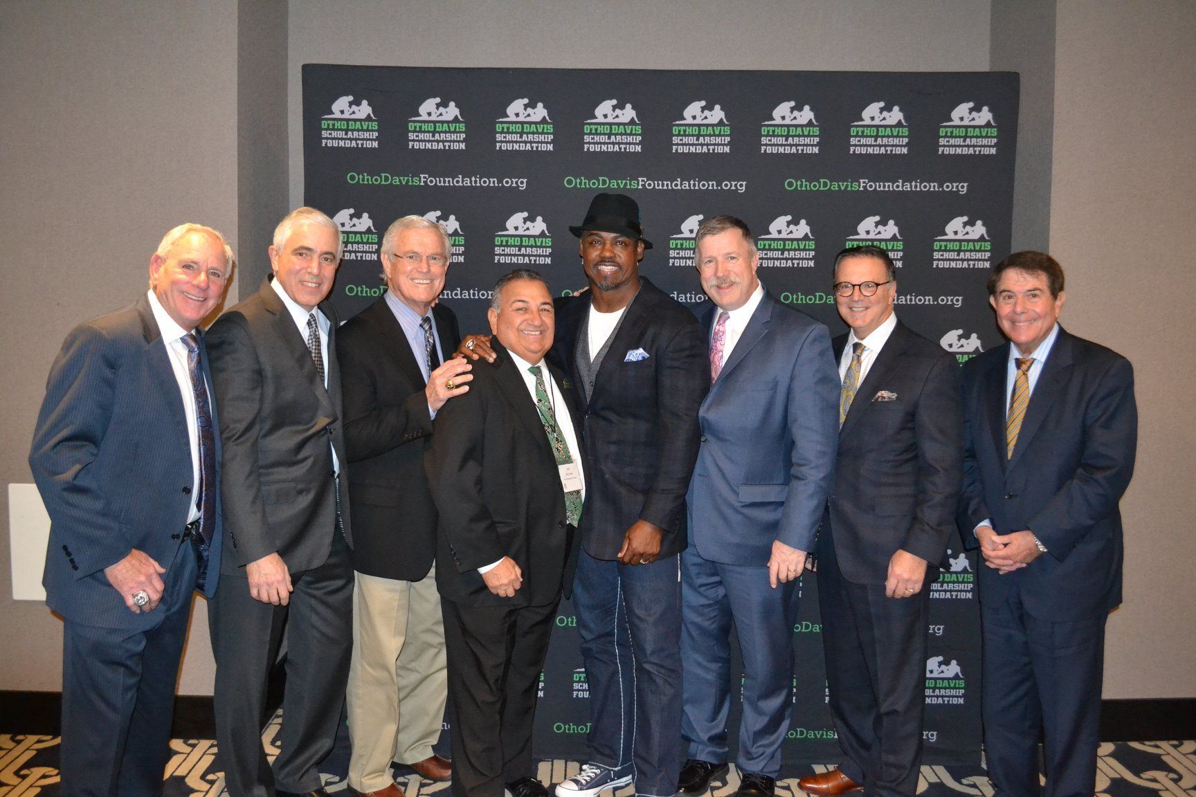 A group of men in suits and ties pose for a picture