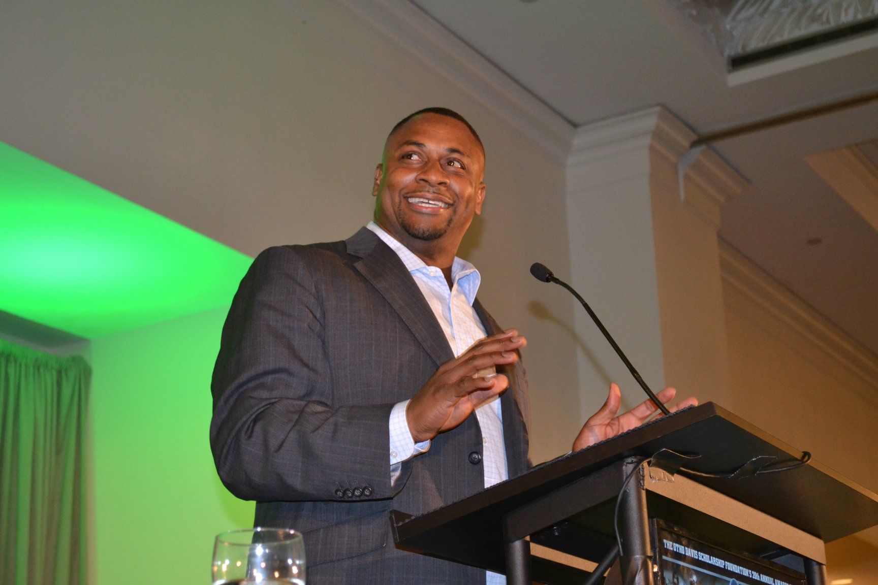 A man in a suit is giving a speech at a podium.