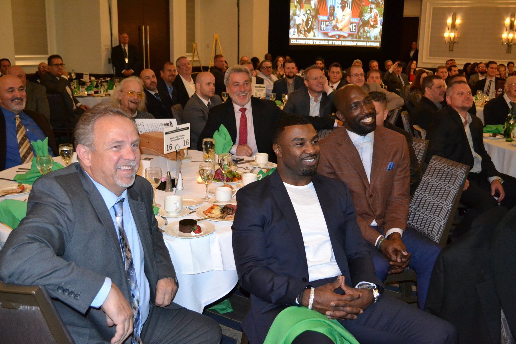 A group of men are sitting at tables in a room.