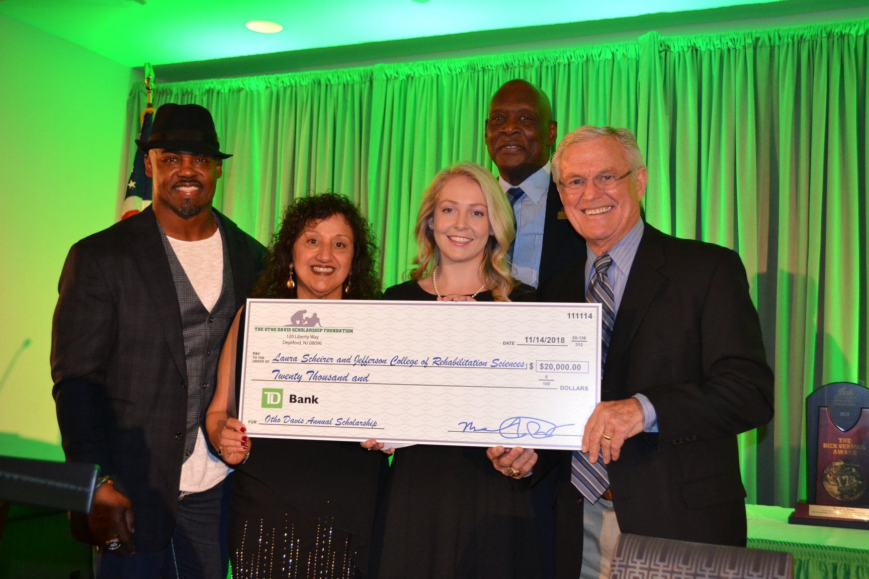 A group of people standing next to each other holding a large check.