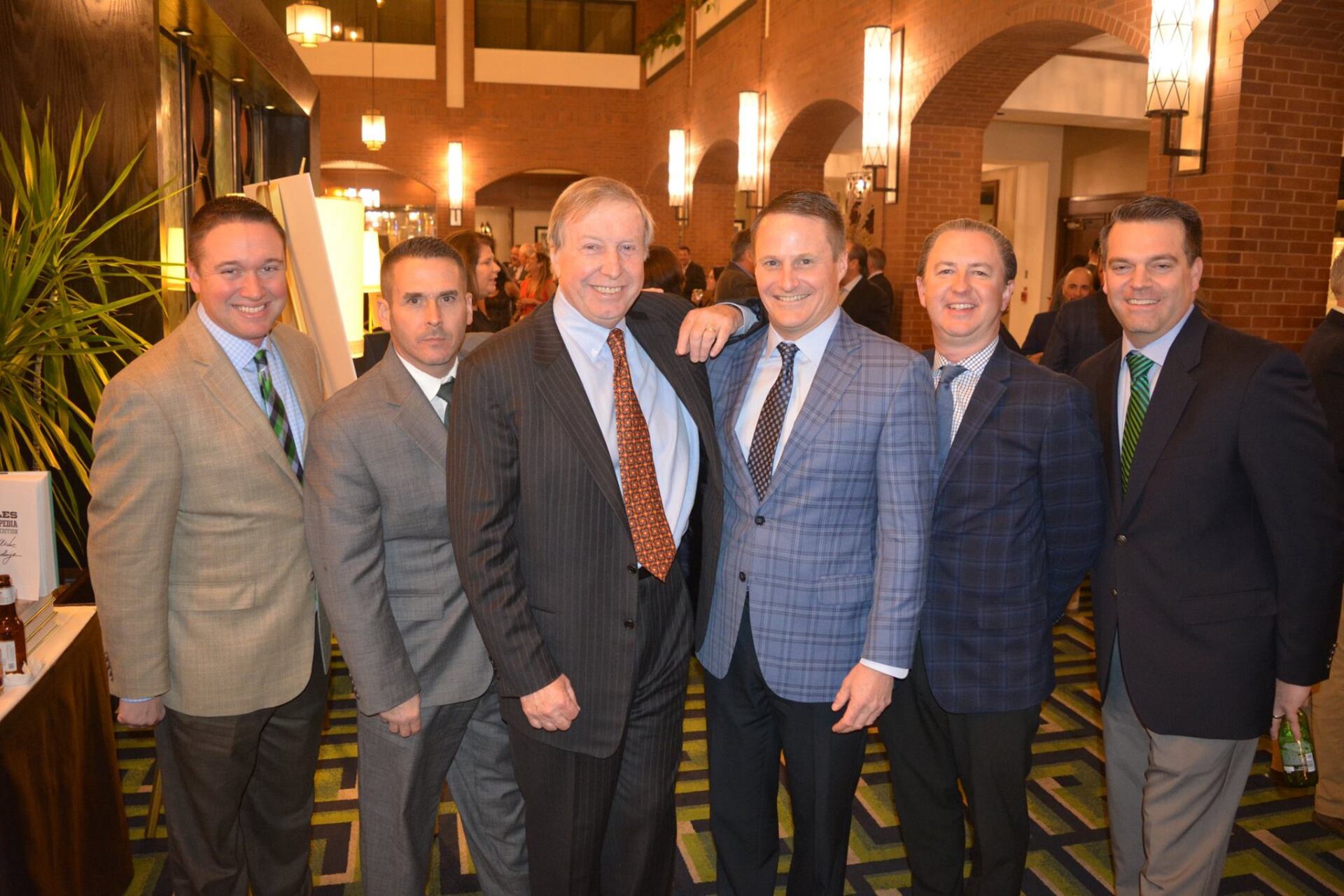 A group of men in suits and ties are posing for a picture.