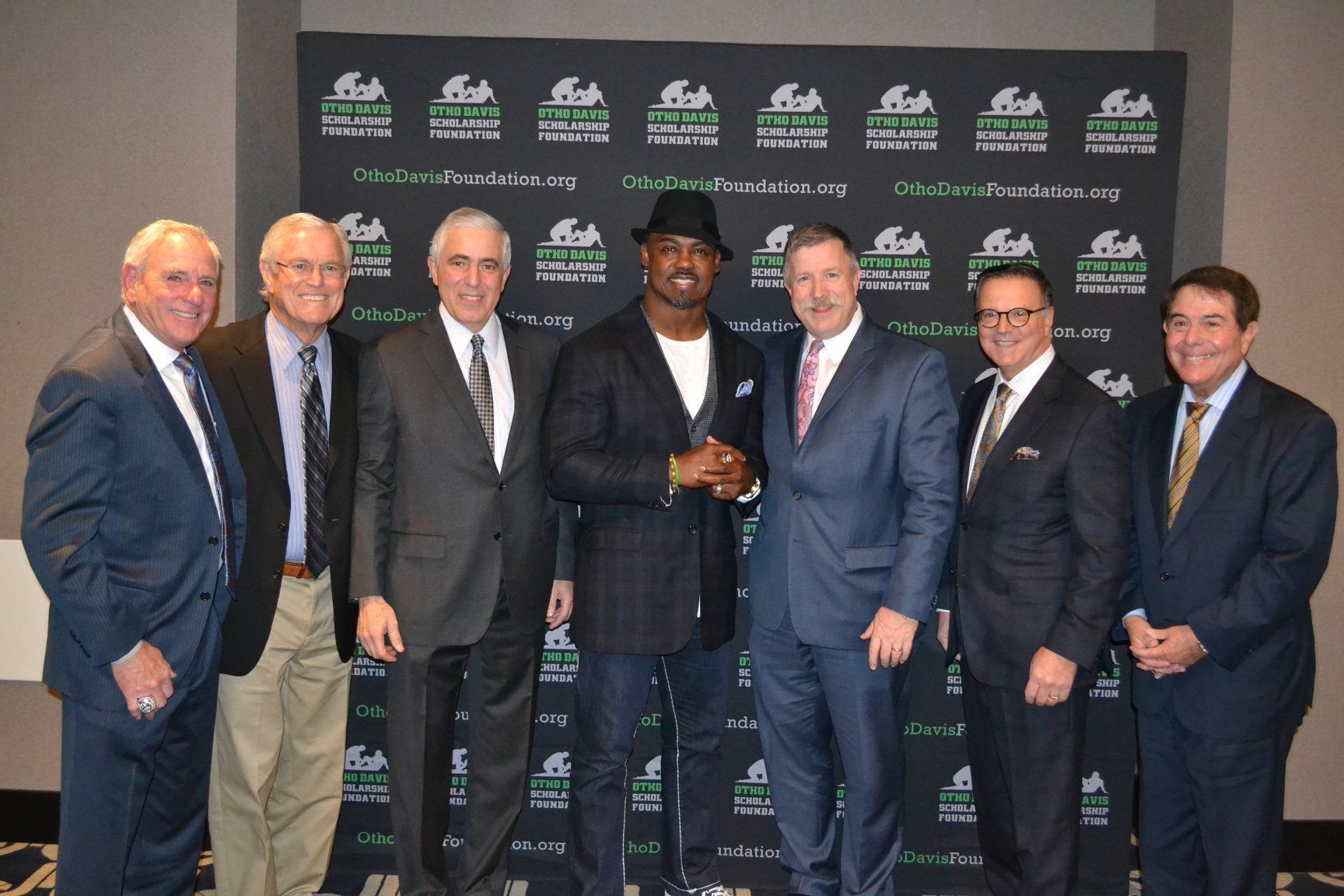A group of men in suits and ties pose for a picture