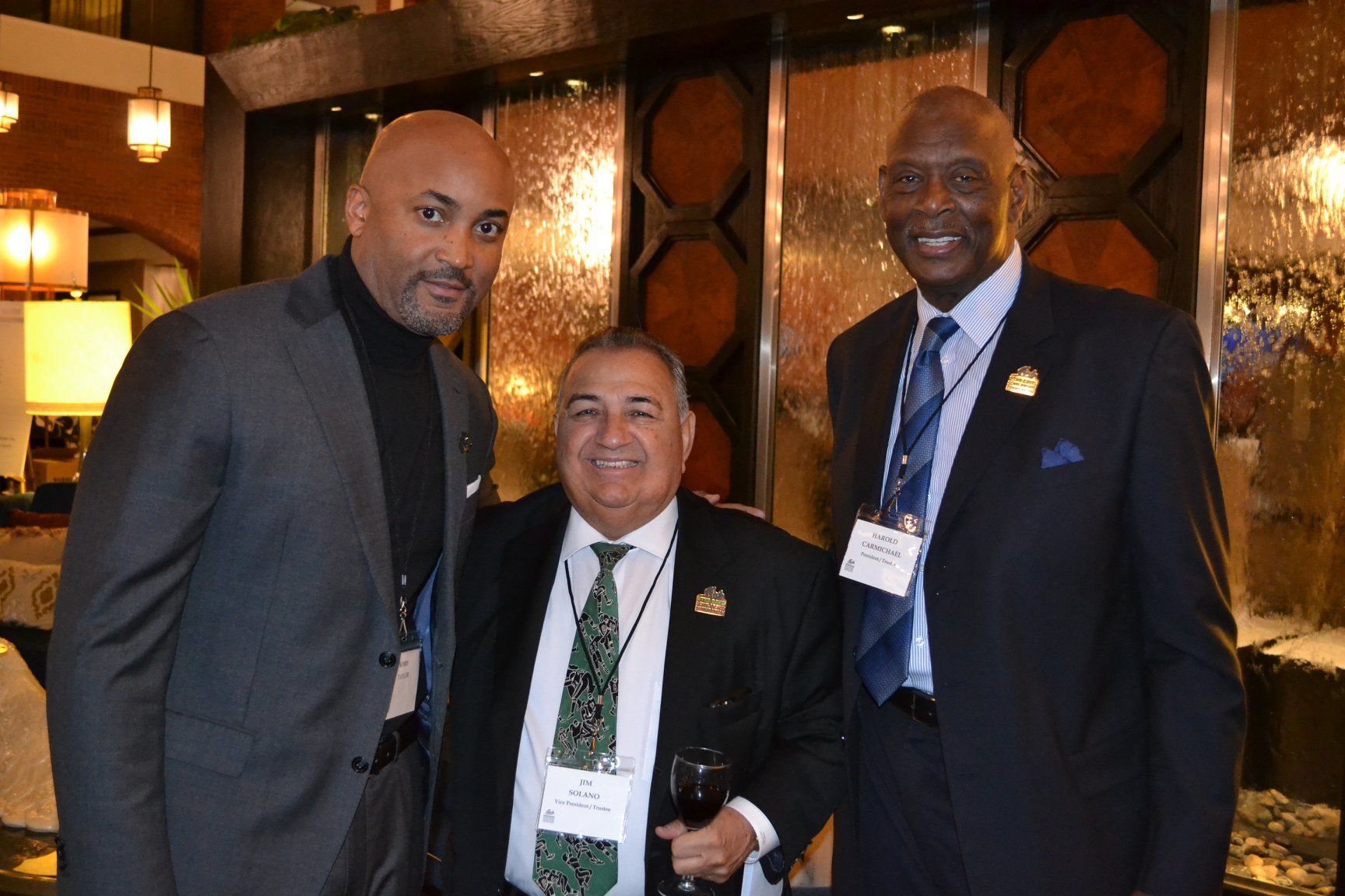 Three men in suits and ties pose for a picture