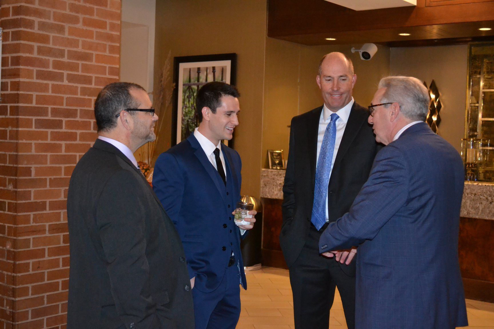 A group of men in suits are standing next to each other and talking.