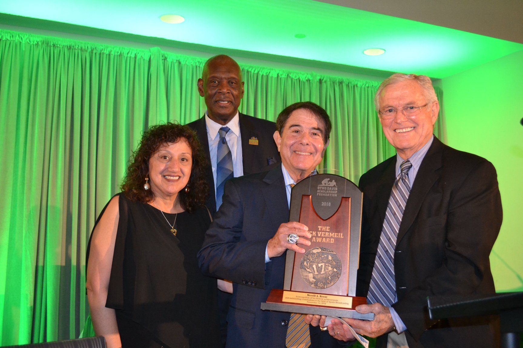 A group of people are posing for a picture while holding a trophy.