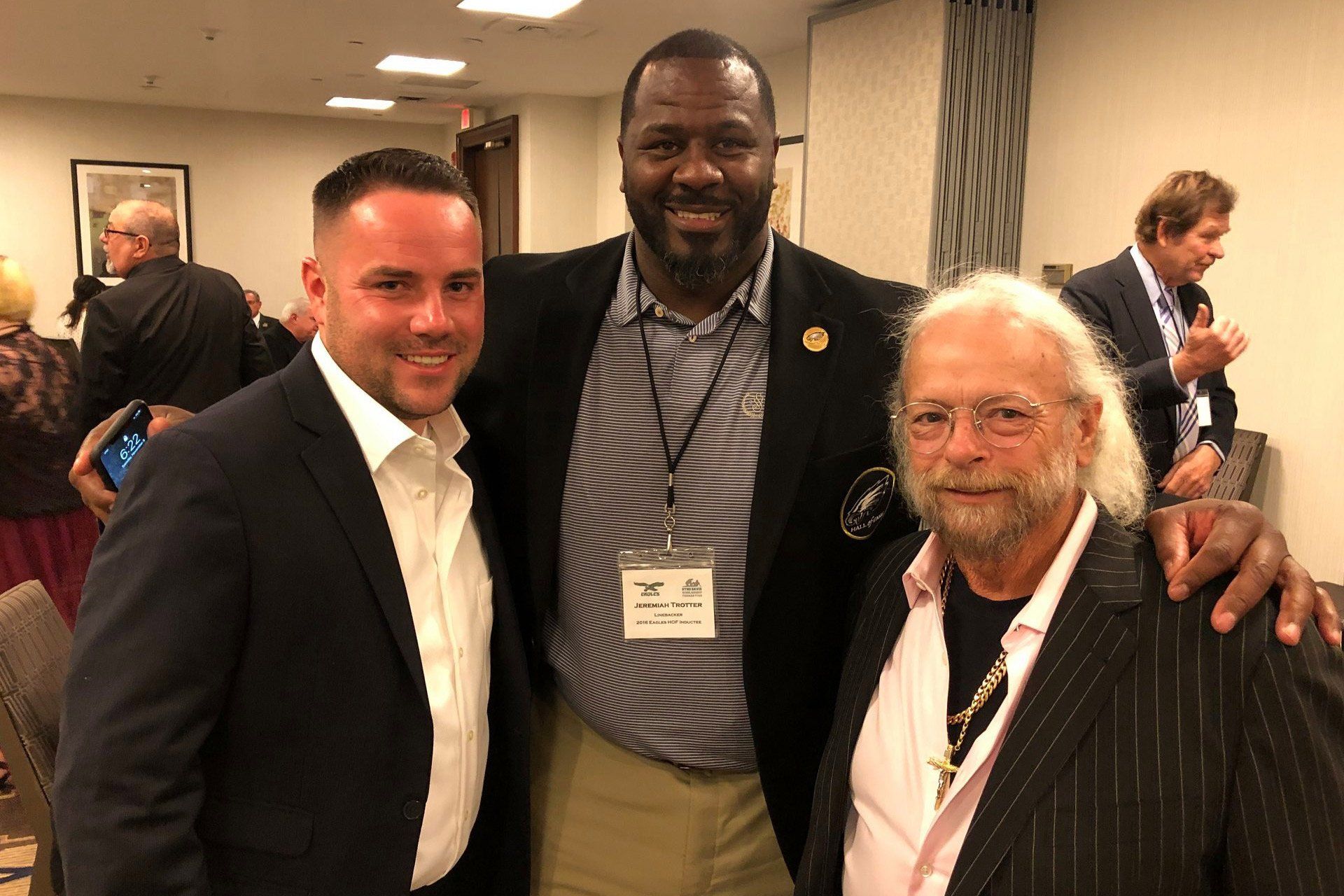 Three men are posing for a picture together in a room.