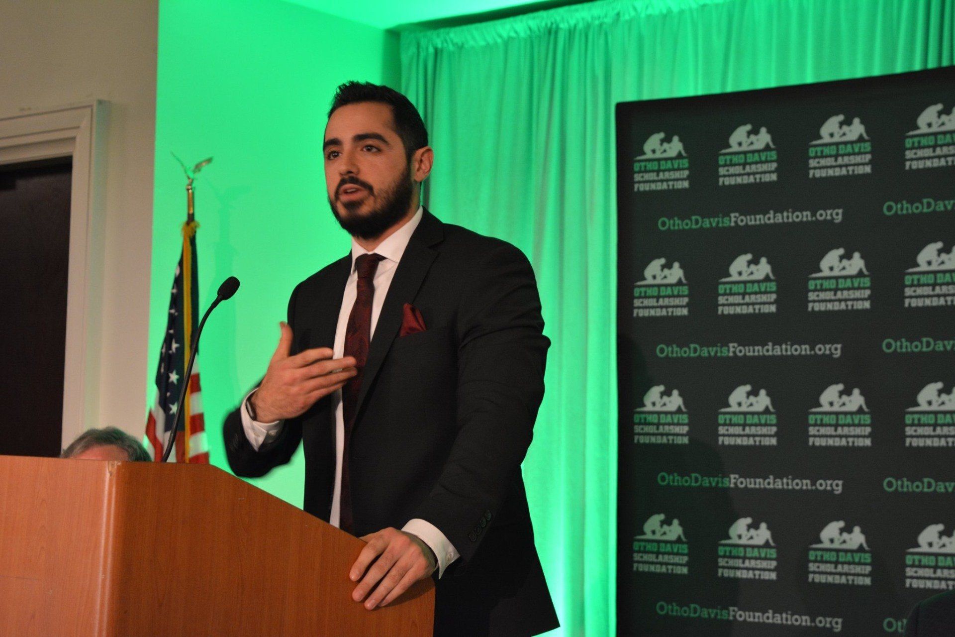 A man in a suit and tie is standing at a podium giving a speech.
