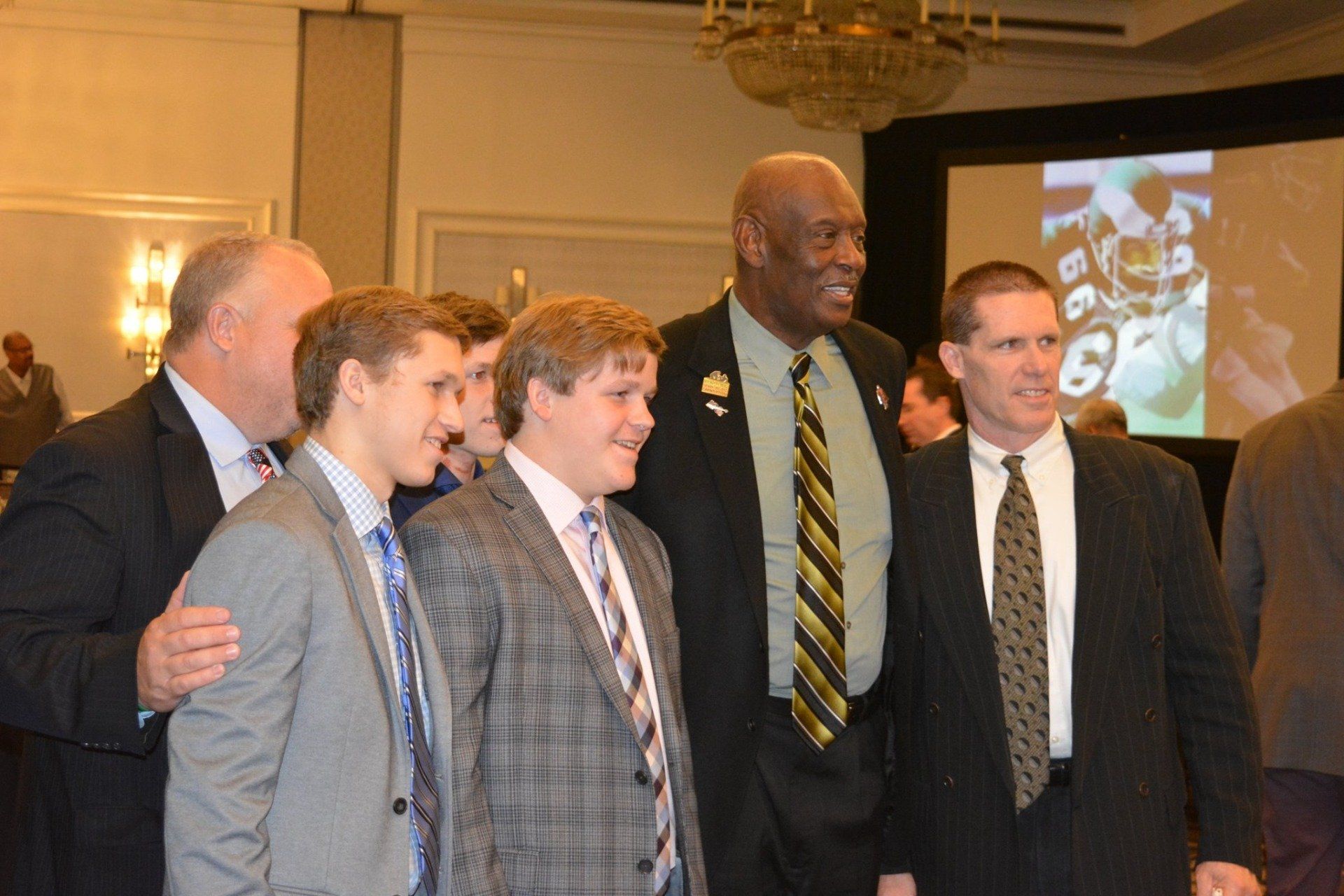 A group of men in suits and ties pose for a picture