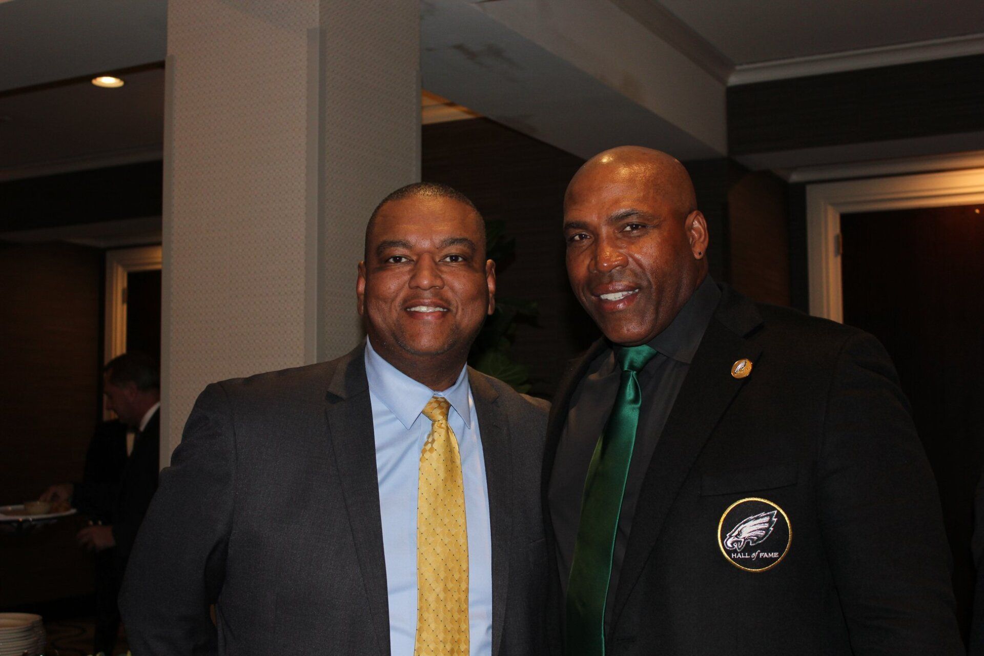 Two men in suits and ties are posing for a picture.