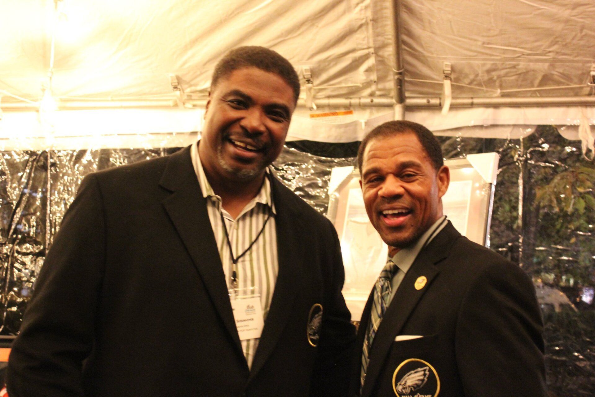 Two men in suits and ties are posing for a picture