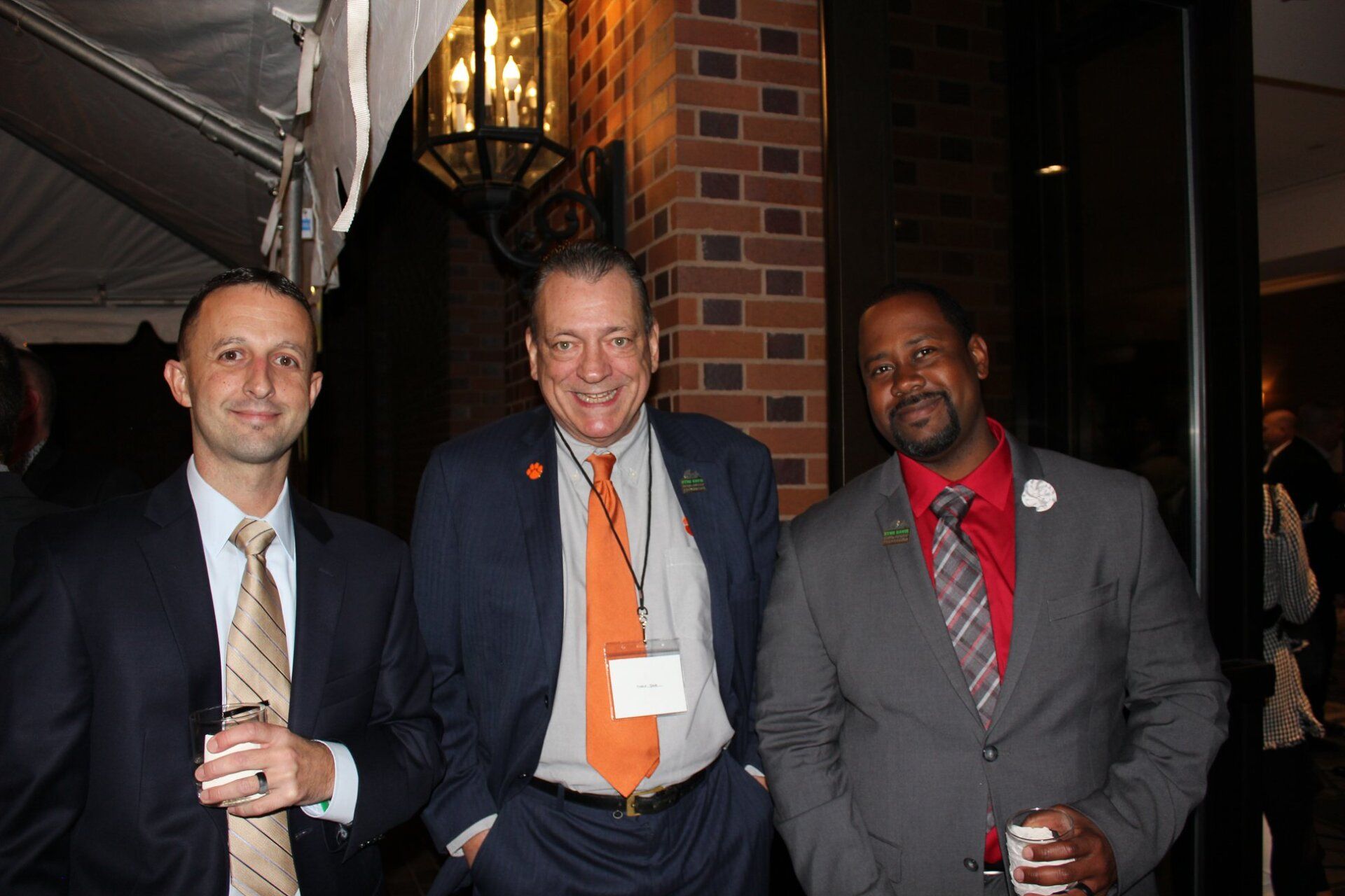 Three men in suits and ties pose for a picture