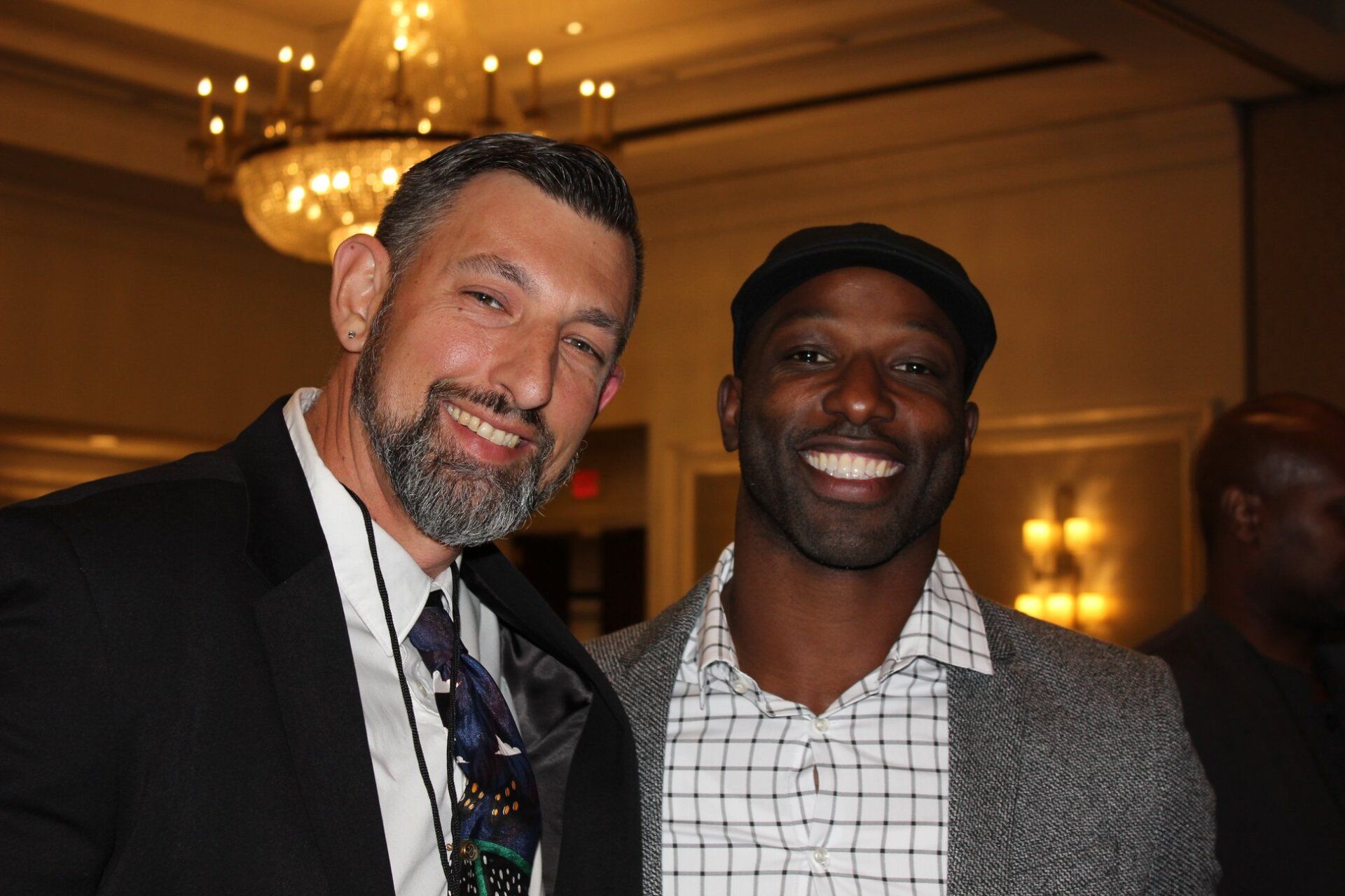 Two men are posing for a picture and smiling for the camera.