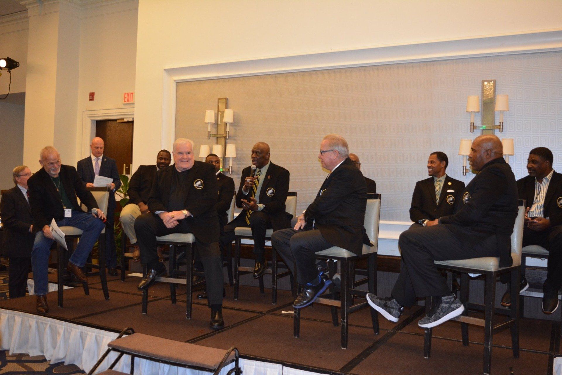A group of men are sitting on stools on a stage.