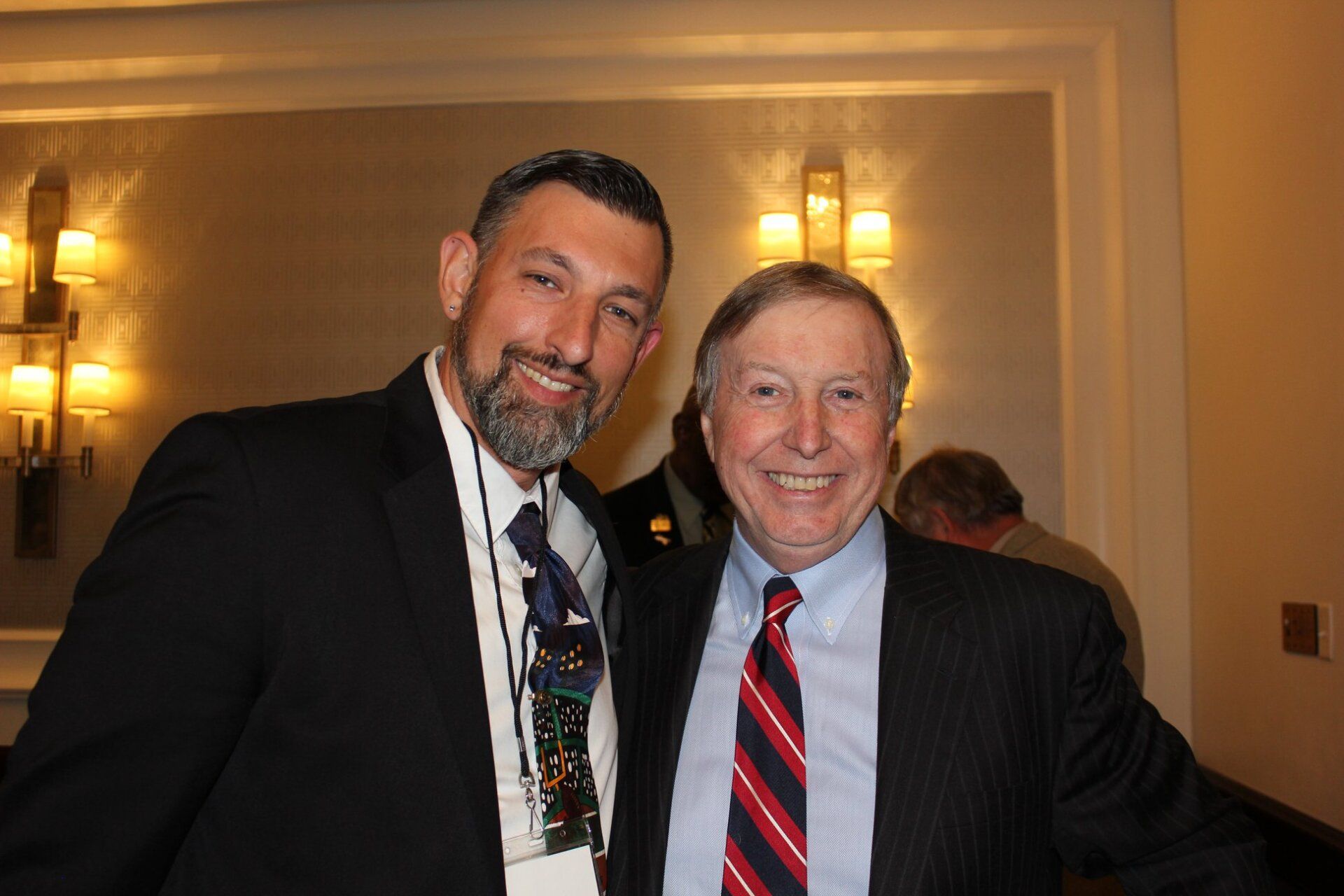 Two men in suits and ties are posing for a picture.