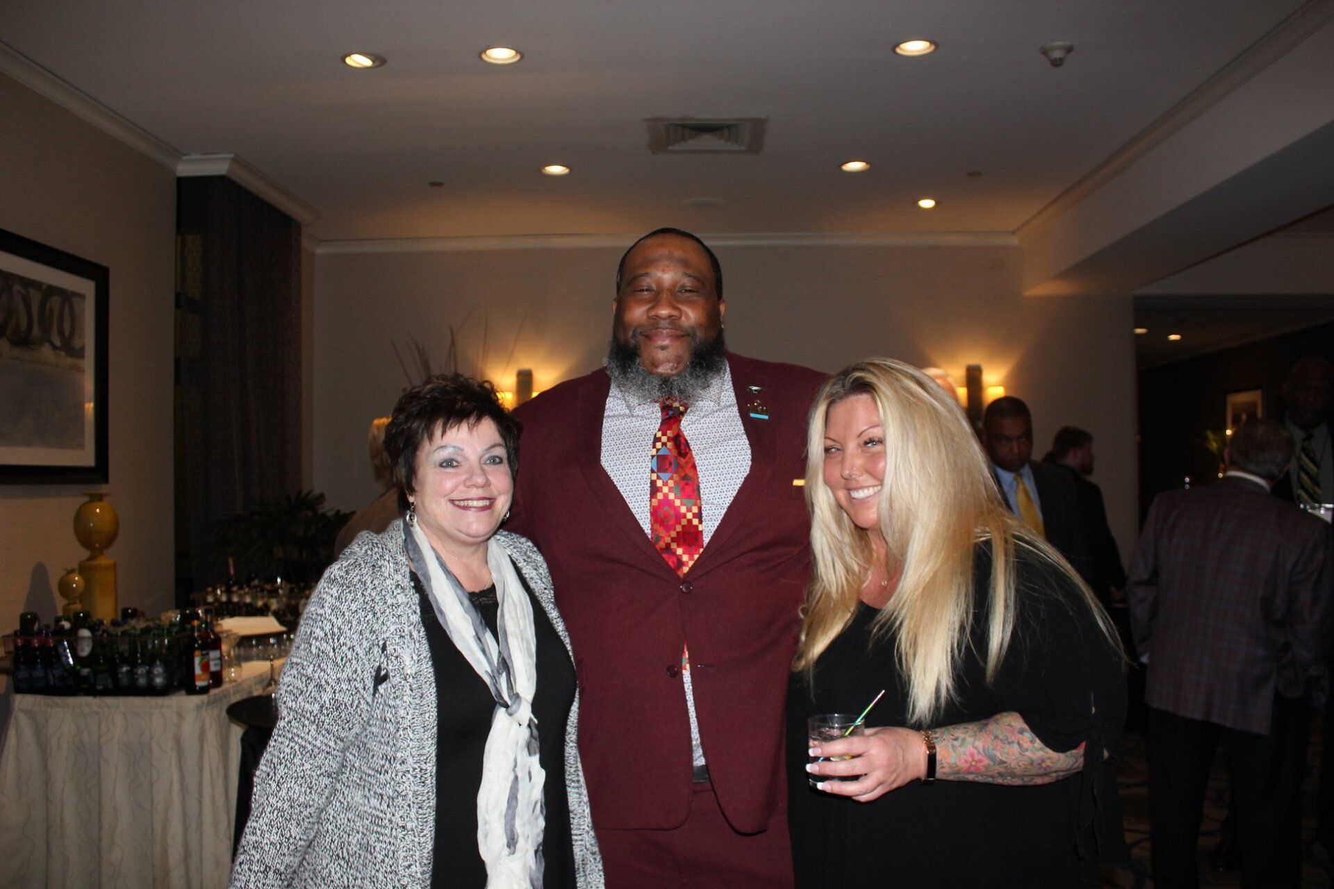 A man in a suit and tie is posing for a picture with two women.