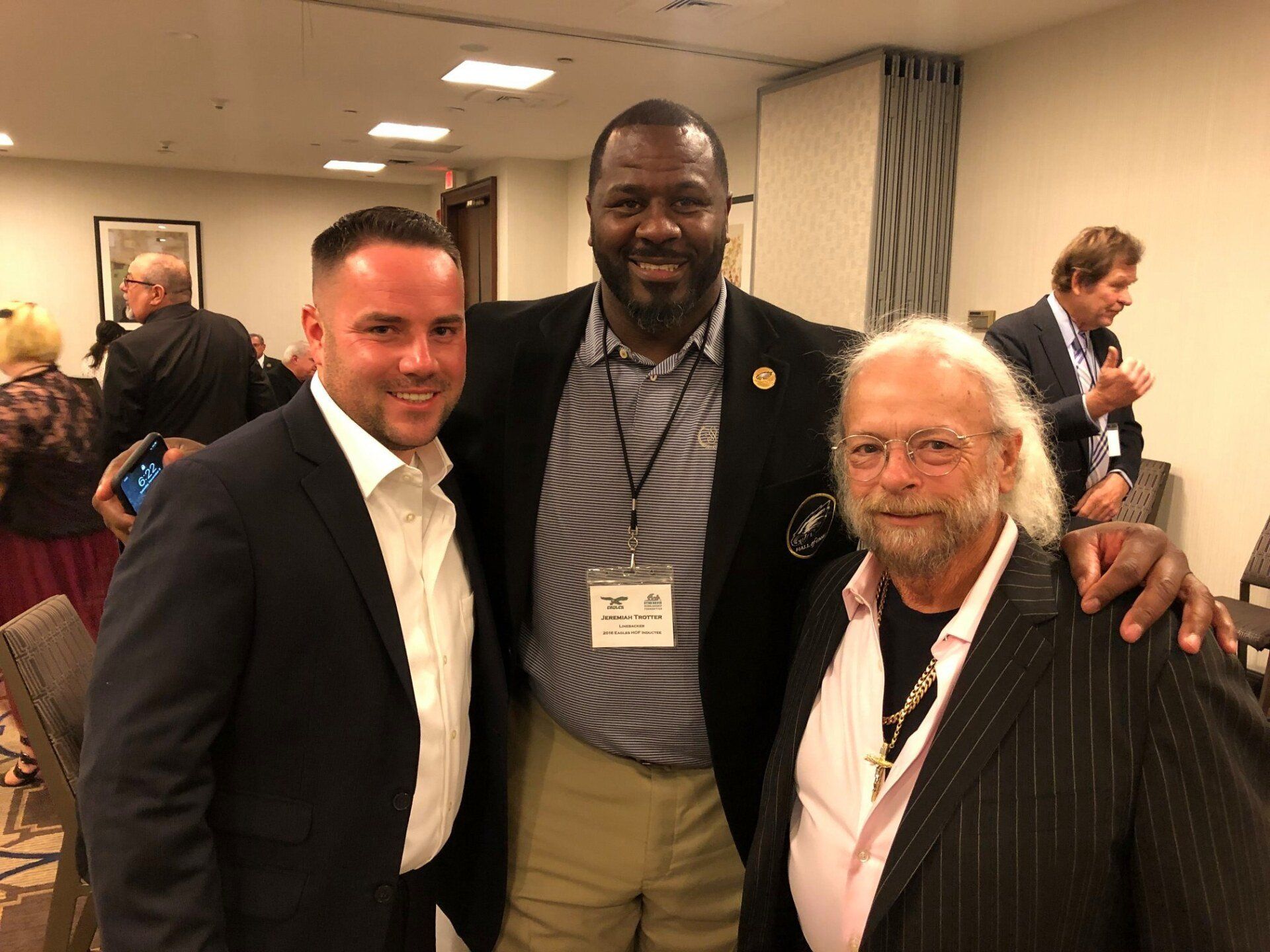 Three men are posing for a picture together in a room.