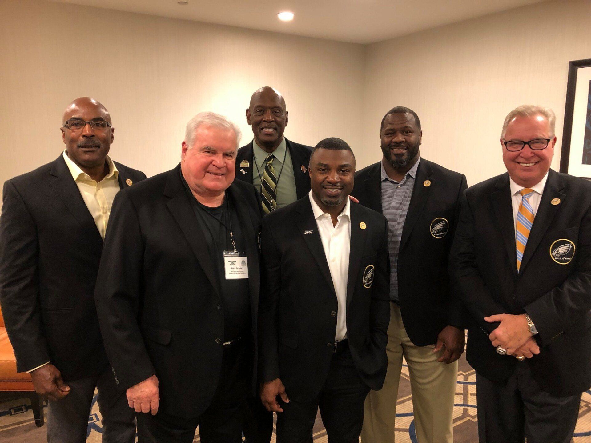 A group of men in suits and ties are posing for a picture.