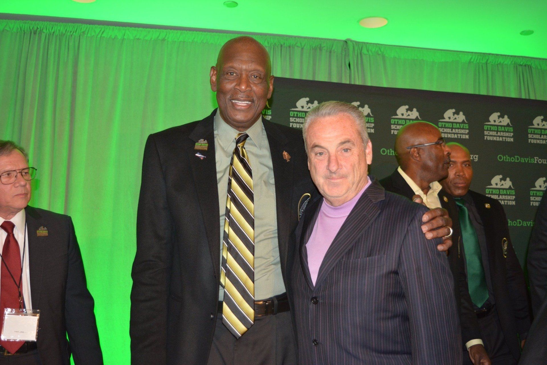 Two men in suits and ties are posing for a picture.