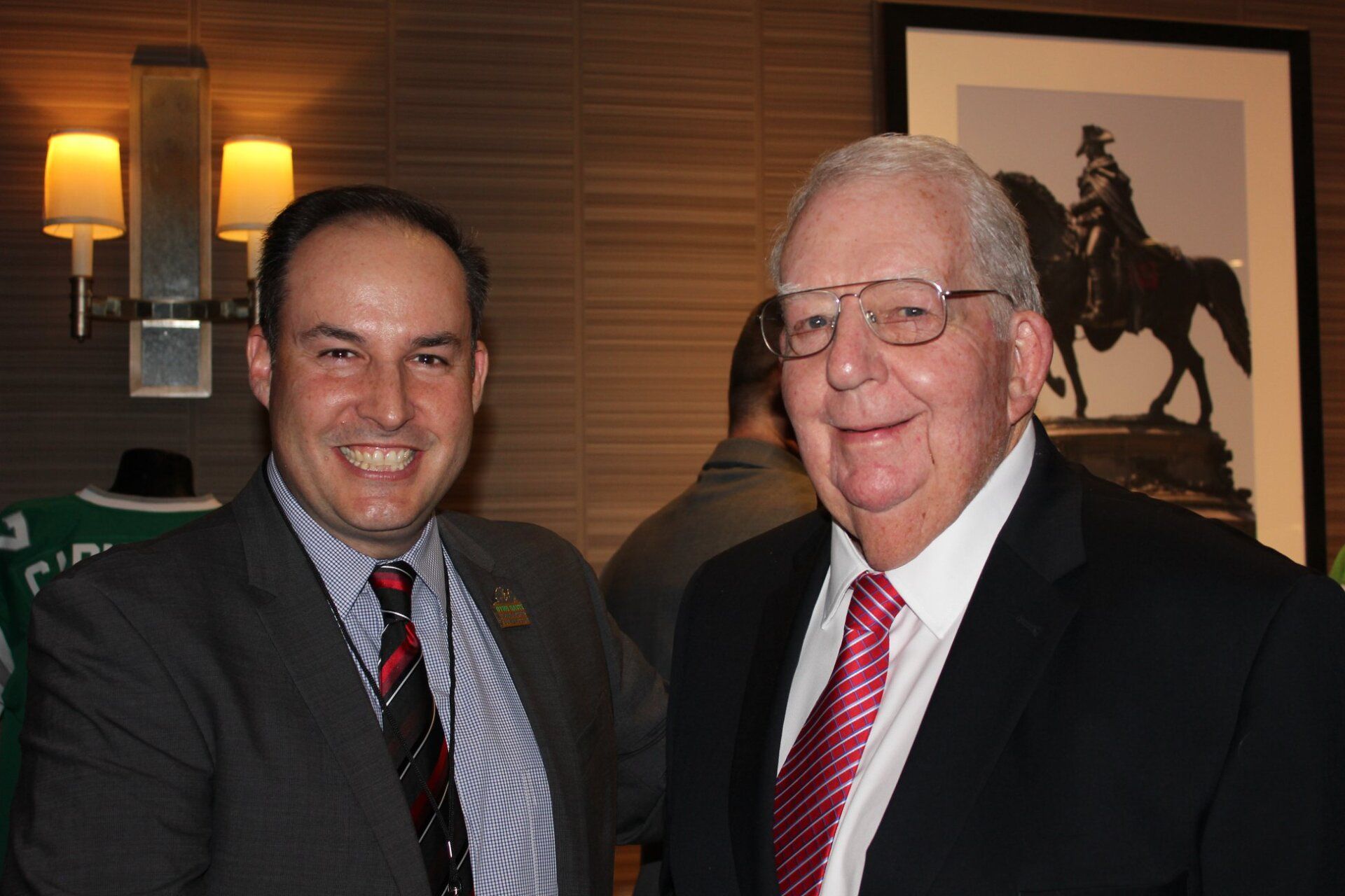 Two men in suits and ties are posing for a picture