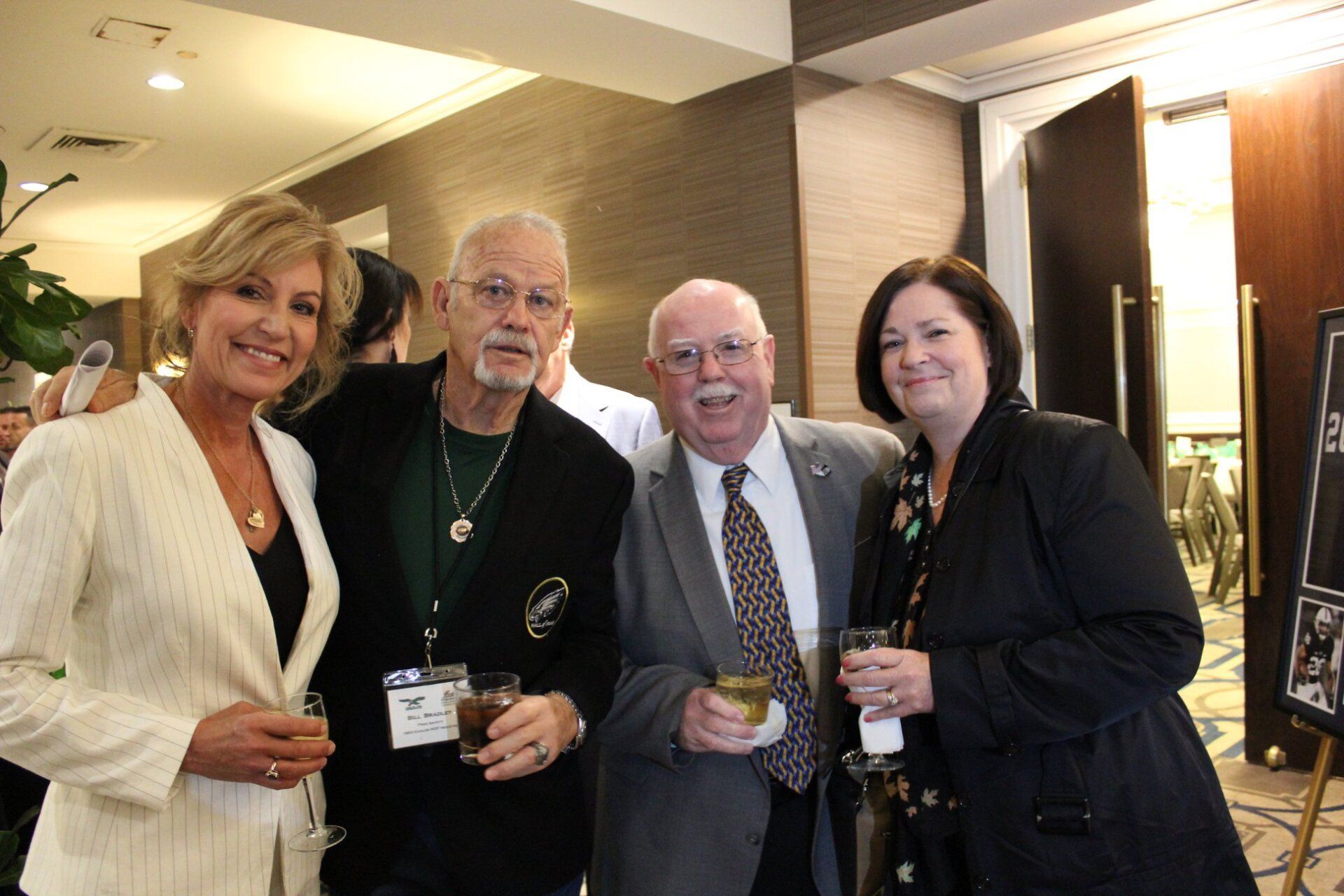 A group of people are posing for a picture while holding drinks.