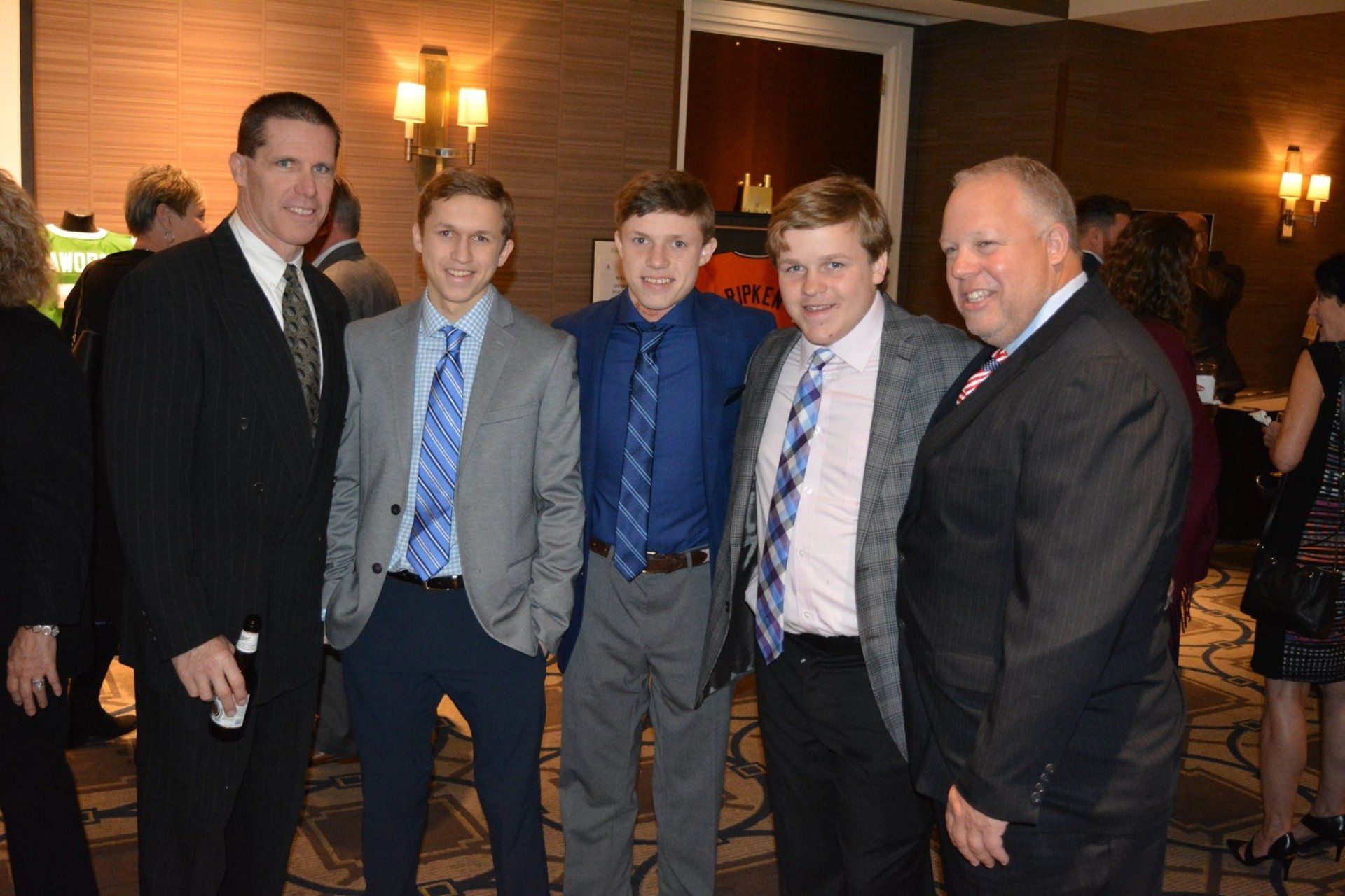 A group of men in suits and ties are posing for a picture.