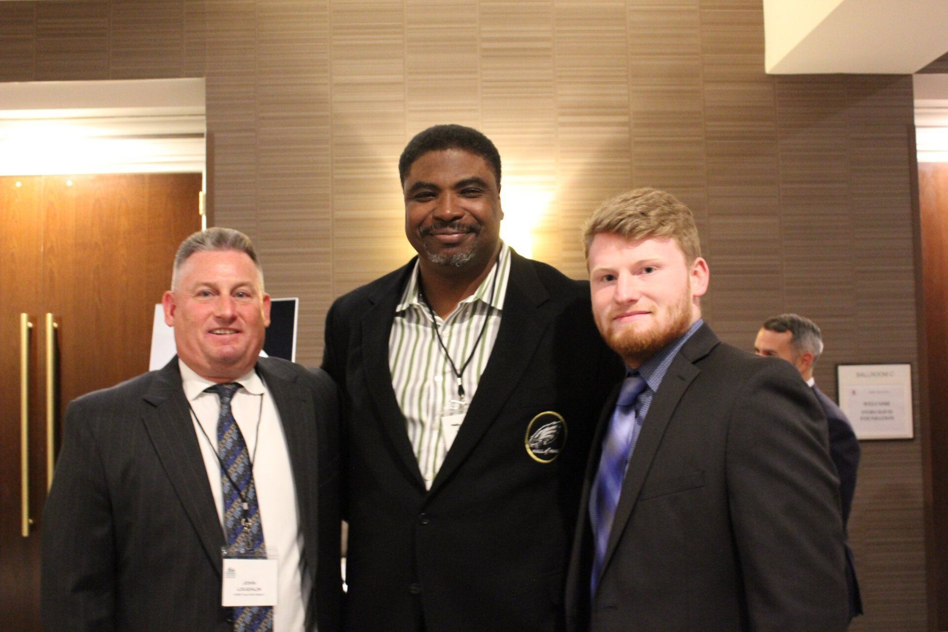 Three men in suits and ties are posing for a picture.