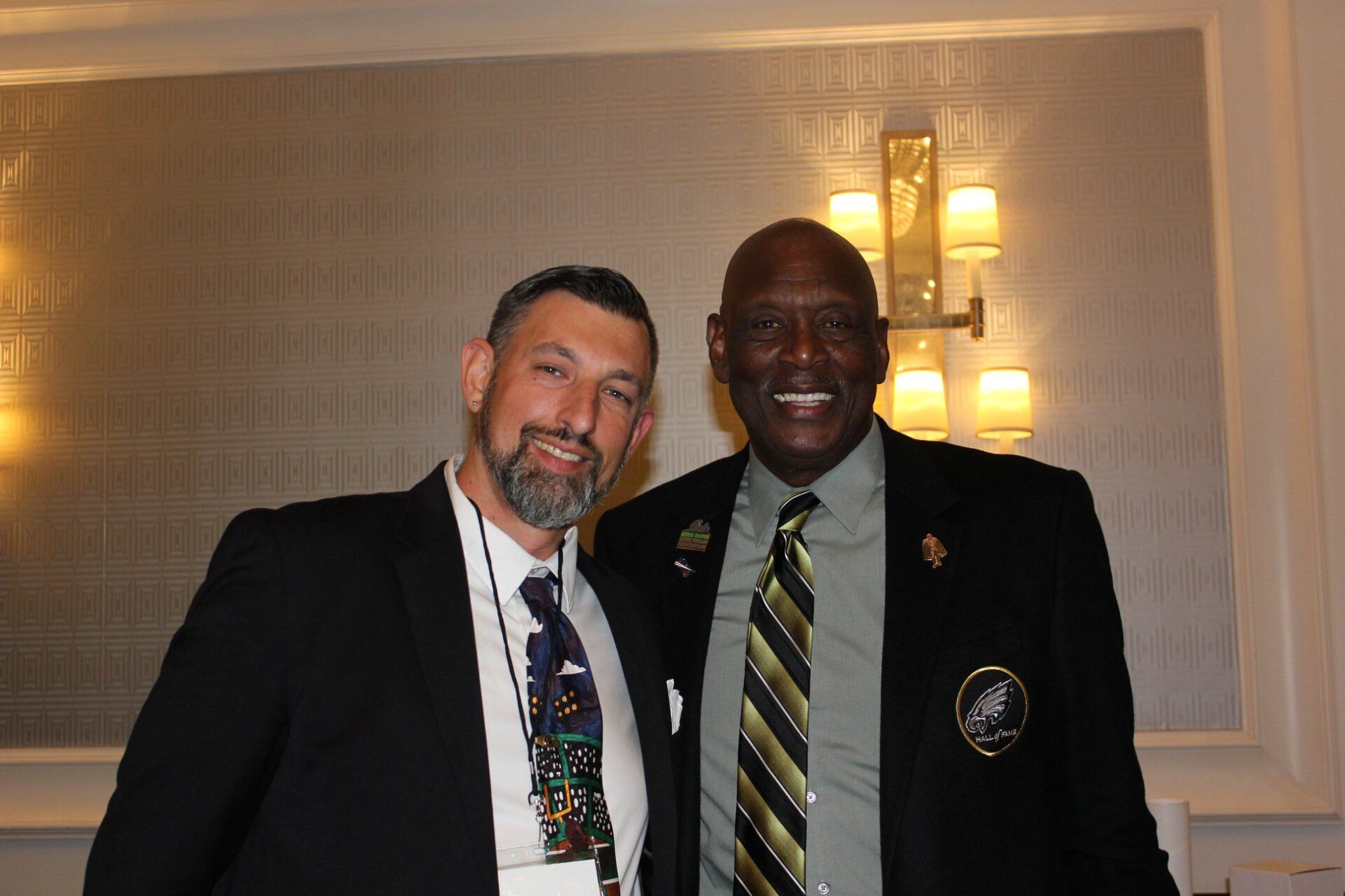 Two men in suits and ties are posing for a picture.