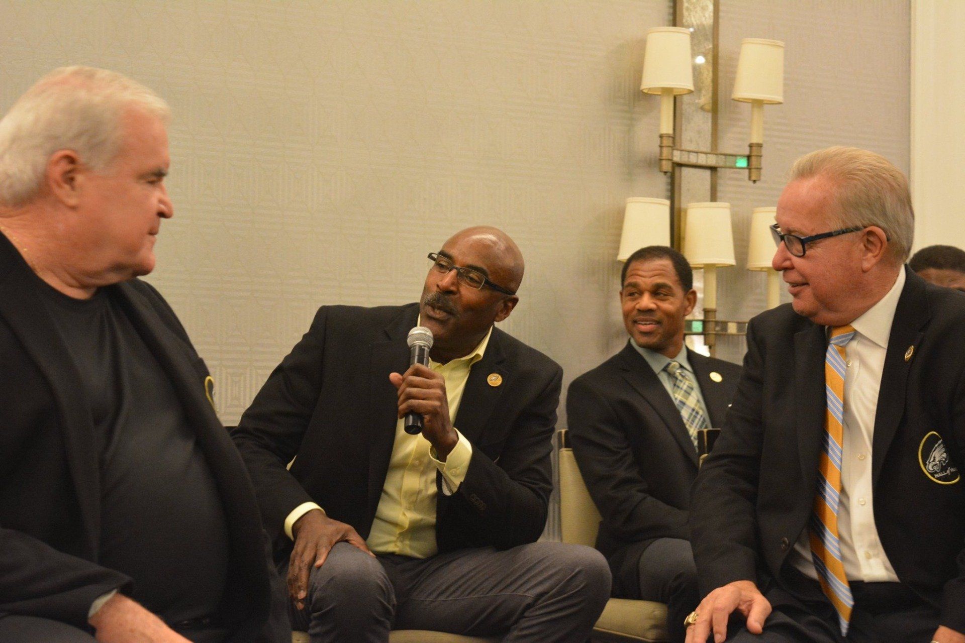 A group of men are sitting in a circle talking to each other.