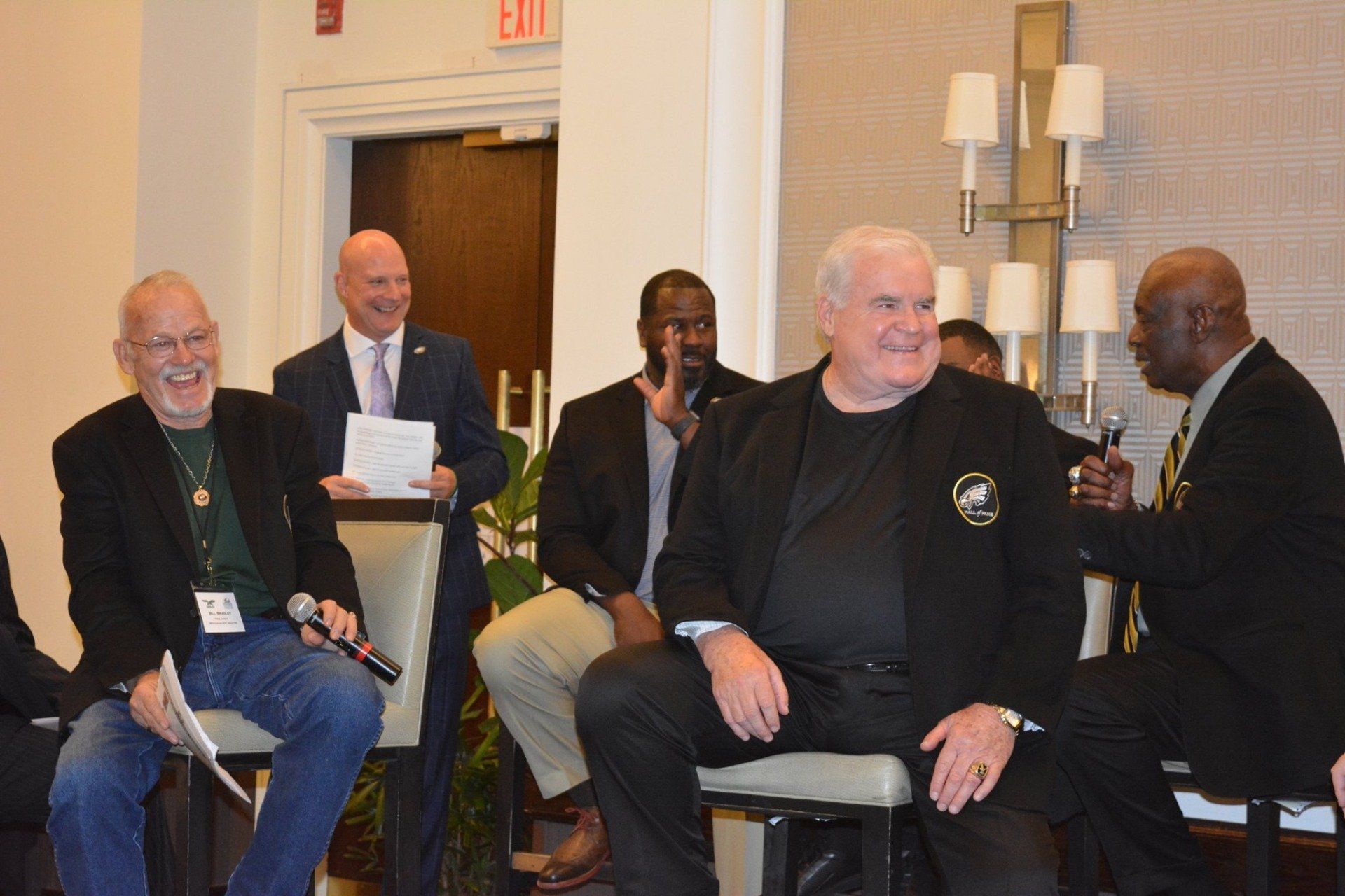 A group of men are sitting in chairs in a room.