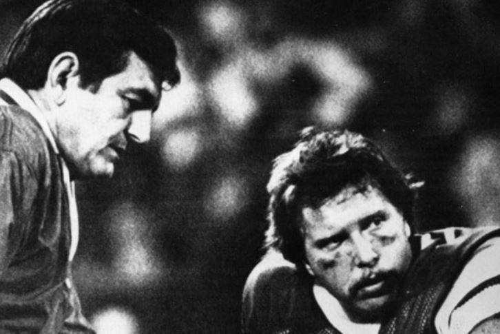 Two men are standing next to each other in a black and white photo.