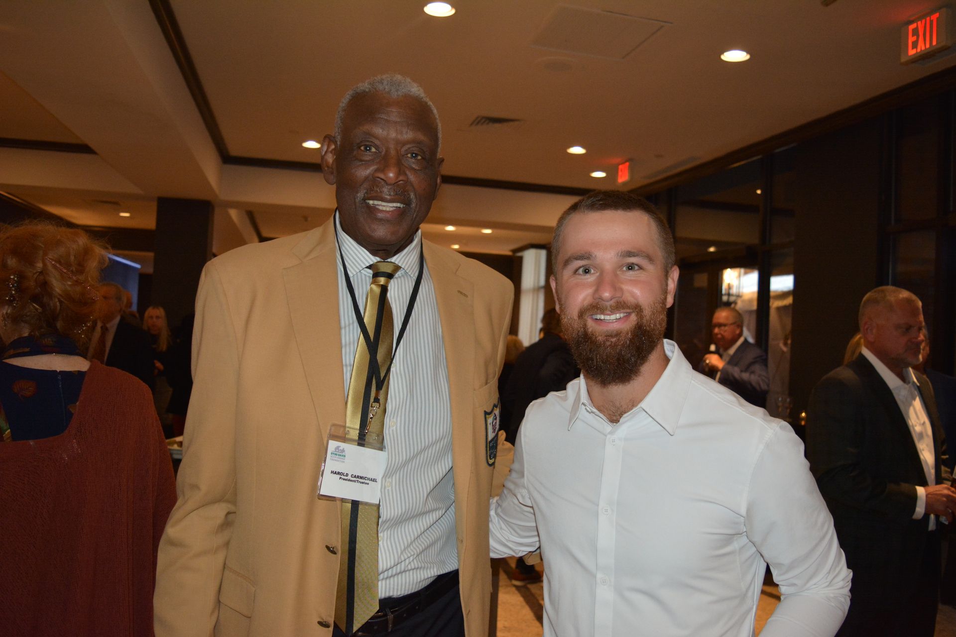 Two men are posing for a picture together in a room.