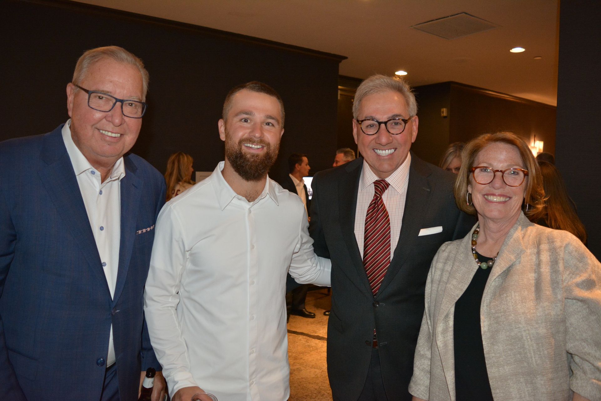 A group of men and a woman are posing for a picture together.