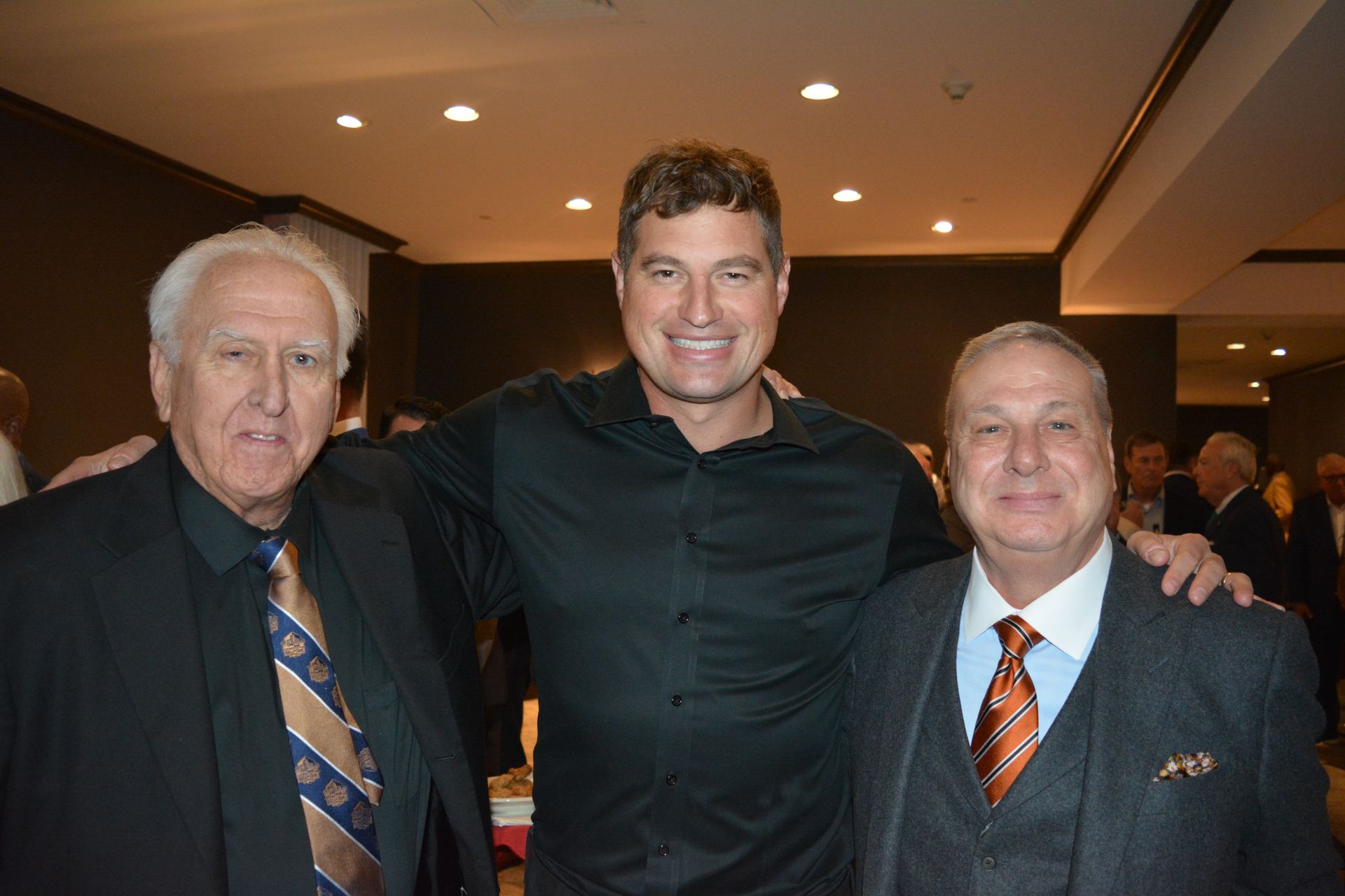 Three men in suits and ties are posing for a picture.