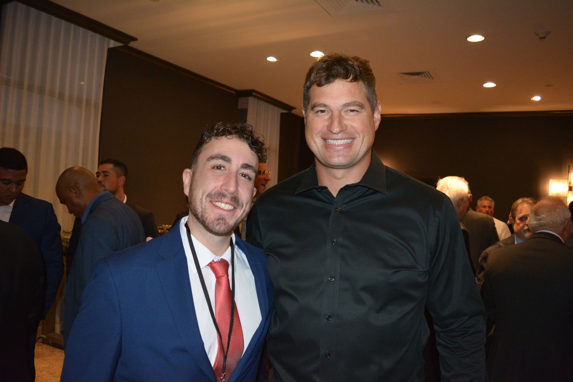 Two men are posing for a picture together in a room.