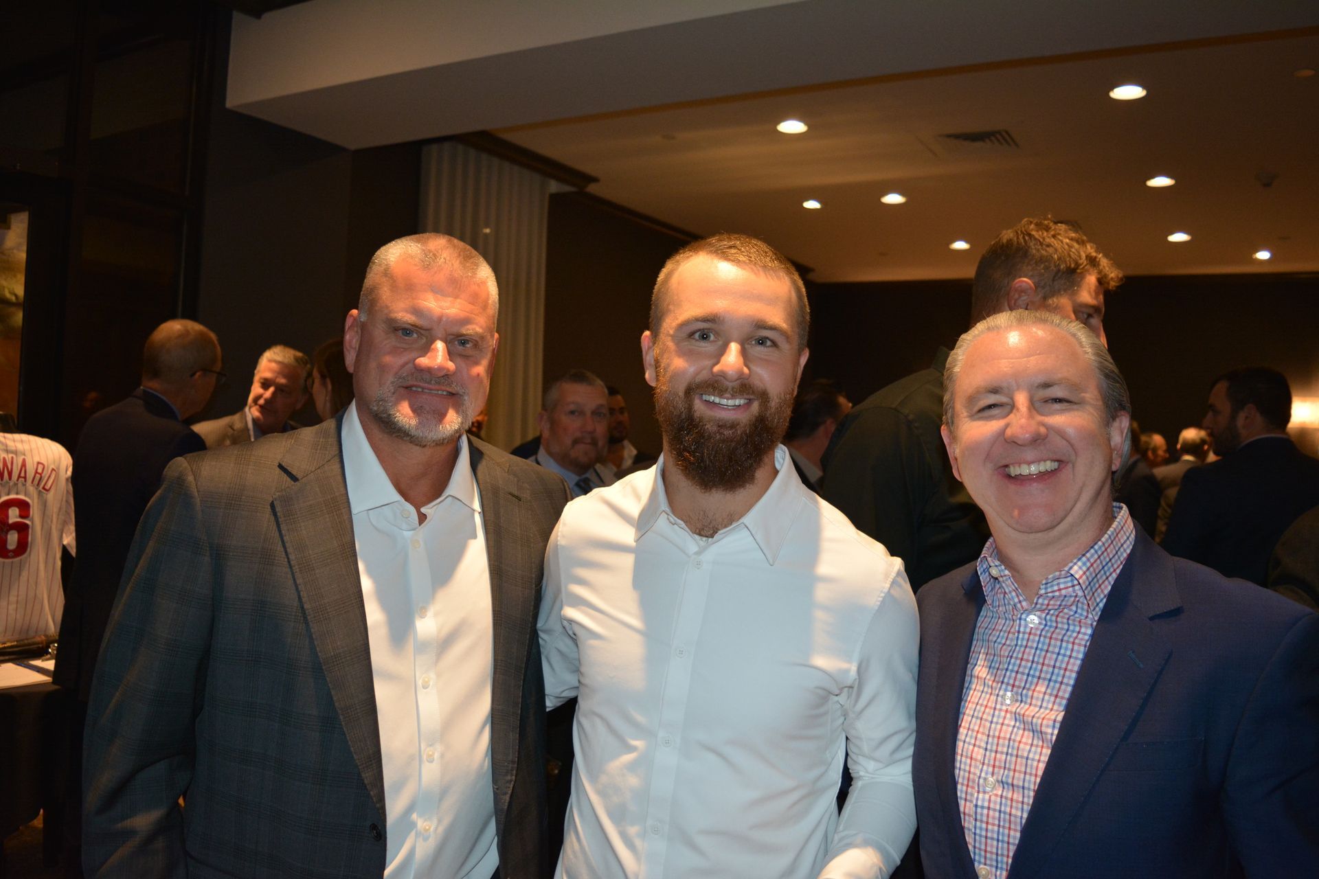 Three men are posing for a picture together in a room.