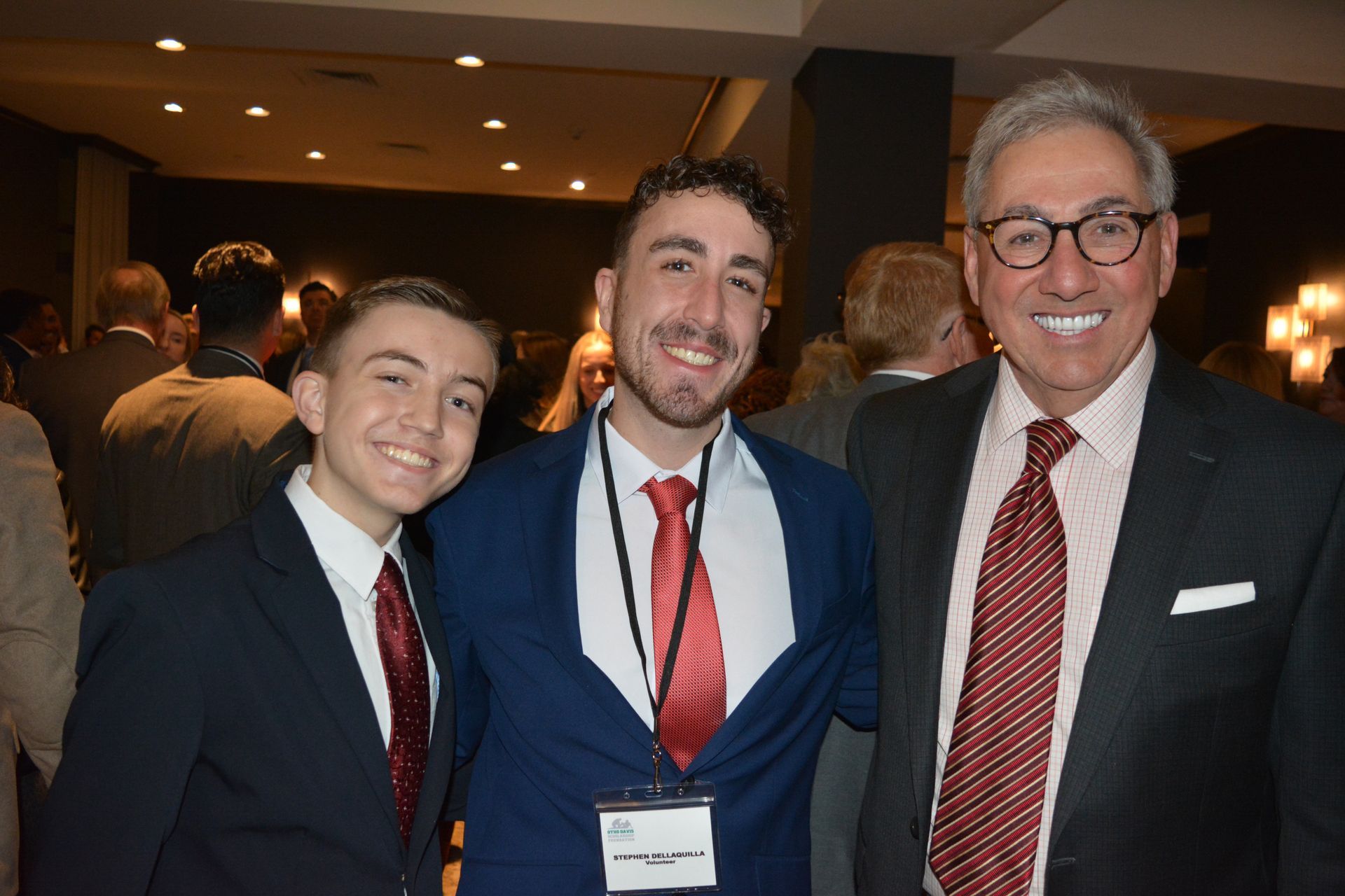 Three men in suits and ties pose for a picture