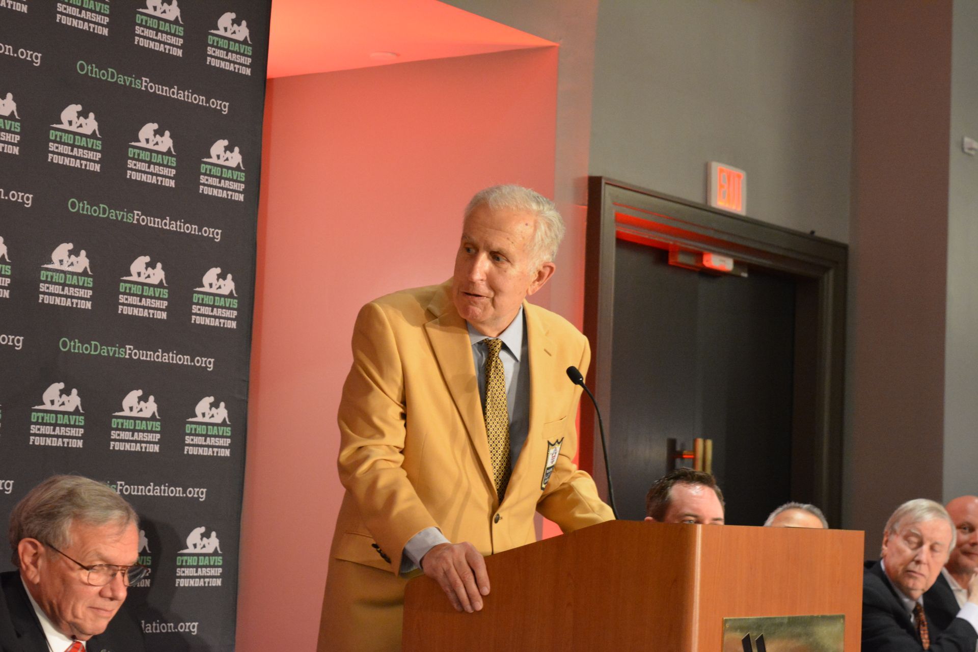 A man in a suit and tie is standing at a podium giving a speech.
