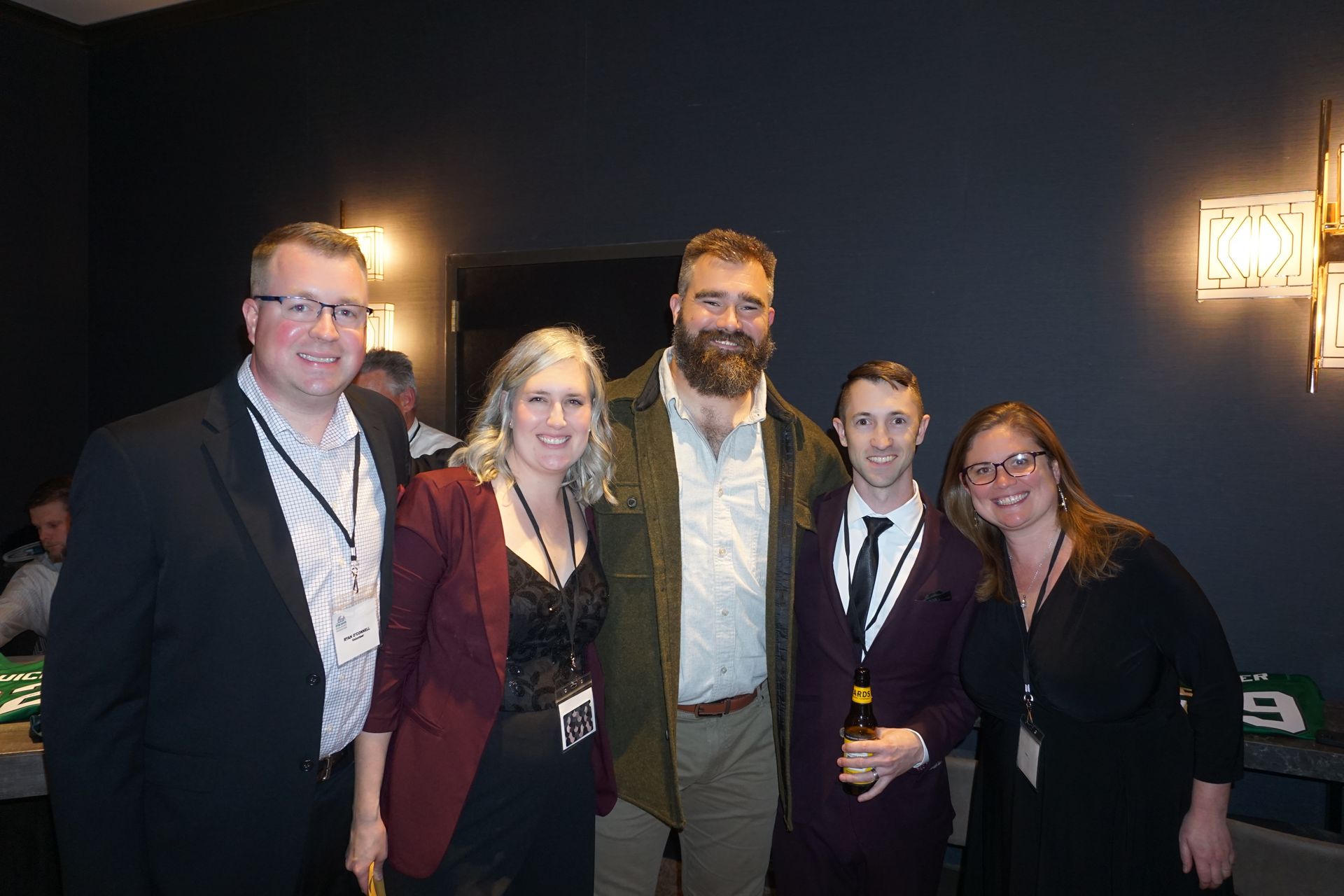A group of people are posing for a picture together in a dark room.