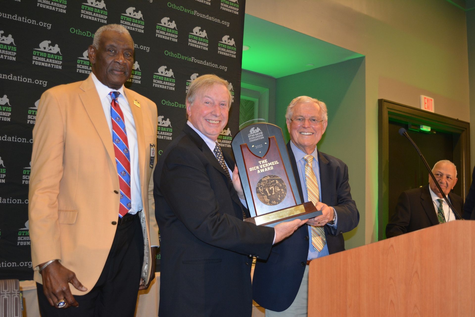 Three men are standing next to each other holding a trophy.