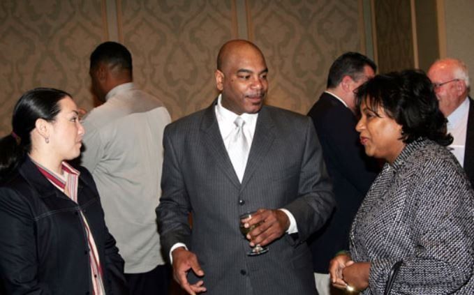 A man in a suit and tie is talking to two women