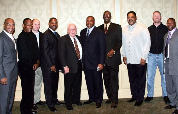 A group of men in suits are posing for a picture