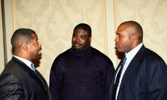 Three men in suits and ties are talking to each other