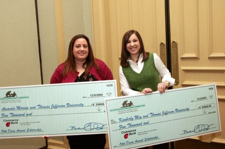 Two women holding a large cheque that says ' a thousand dollars ' on it