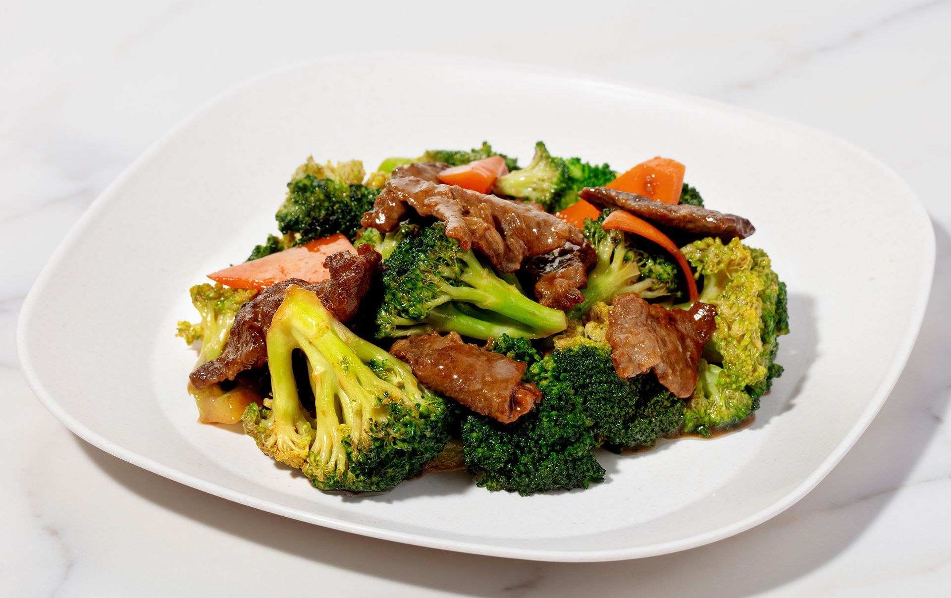 Plate of stir-fried broccoli and beef on a white dish