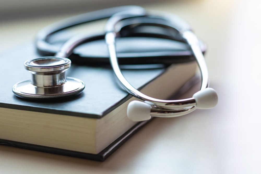 A Stethoscope Is Sitting On Top Of A Book — Mall Medical Centre In Alice Springs, NT