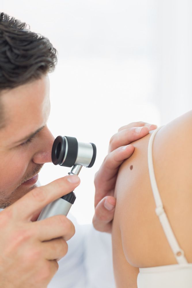 A Doctor Is Examining A Woman 's Skin With A Magnifying Glass — Mall Medical Centre In Alice Springs, NT