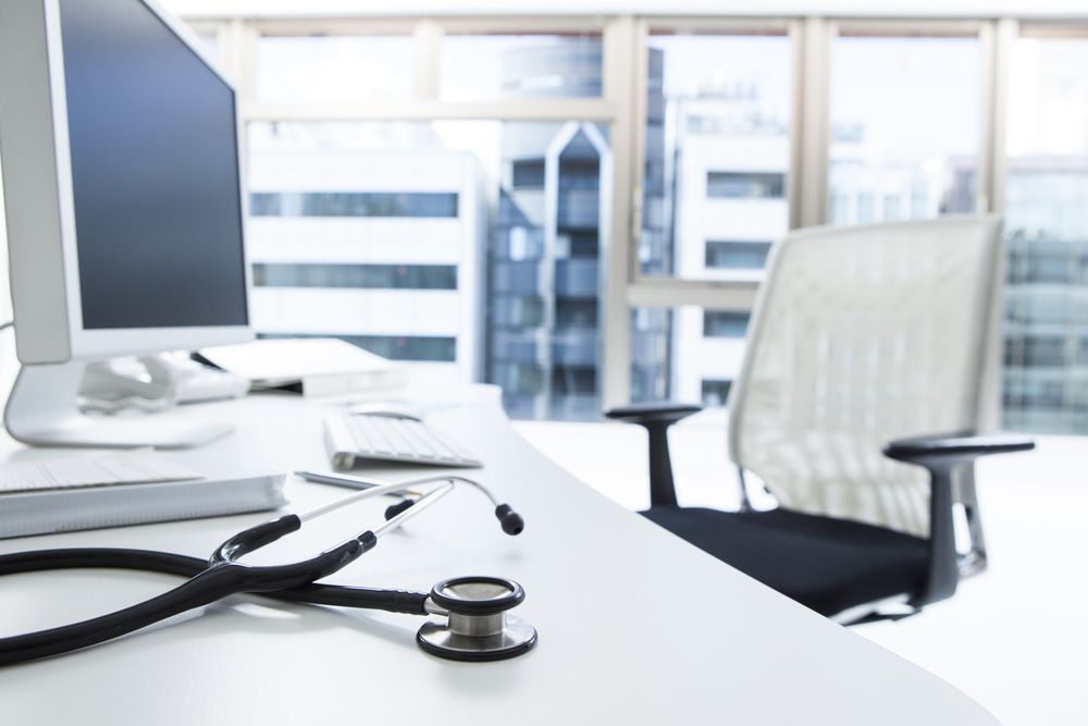 A Stethoscope Is Sitting On A Desk Next To A Computer — Mall Medical Centre In Alice Springs, NT