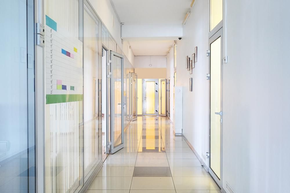 A Long Hallway With A Lot Of Doors And Windows In An Office Building — Mall Medical Centre In Alice Springs, NT