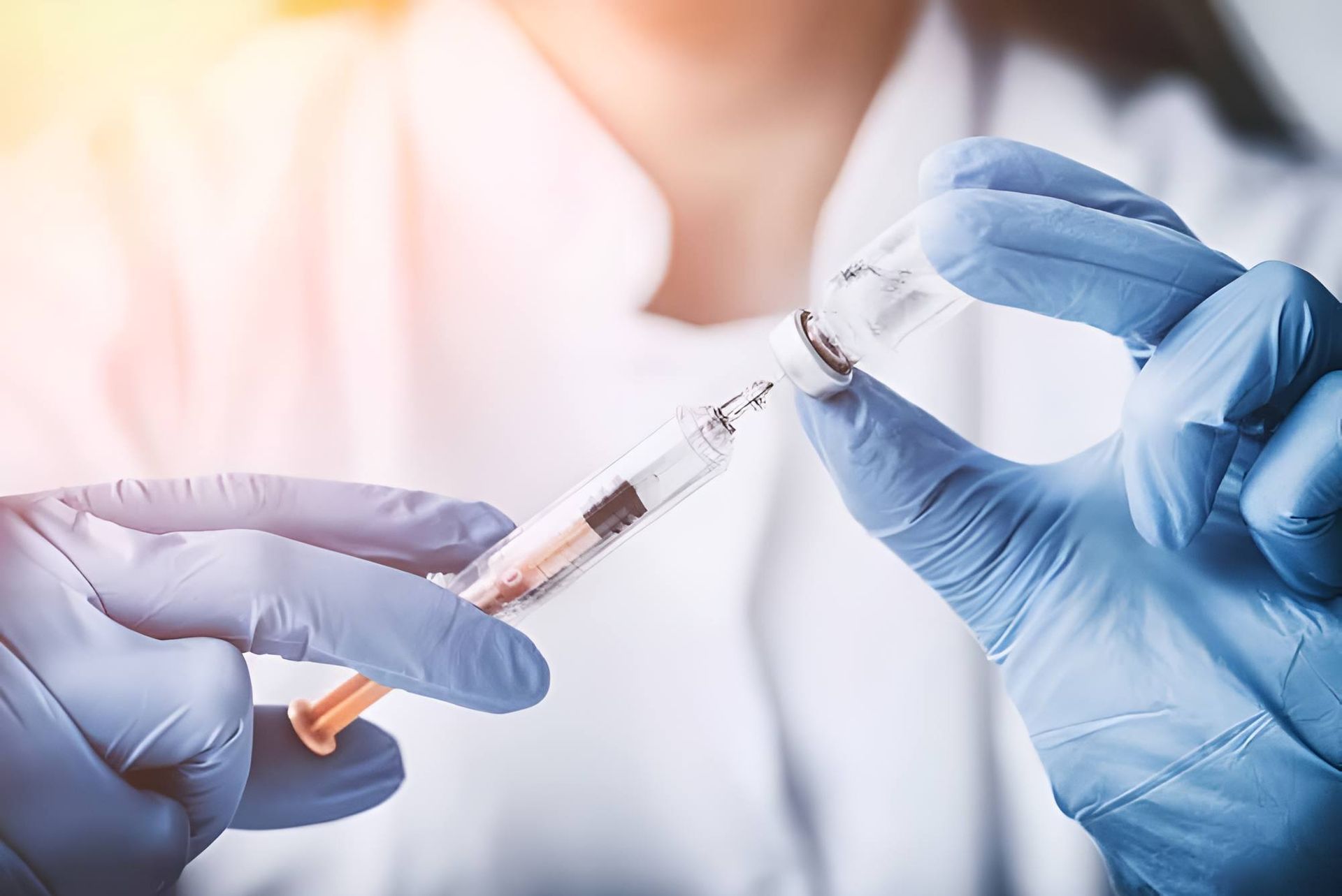 A Doctor Is Holding A Syringe And A Bottle Of Vaccine — Mall Medical Centre In Alice Springs, NT