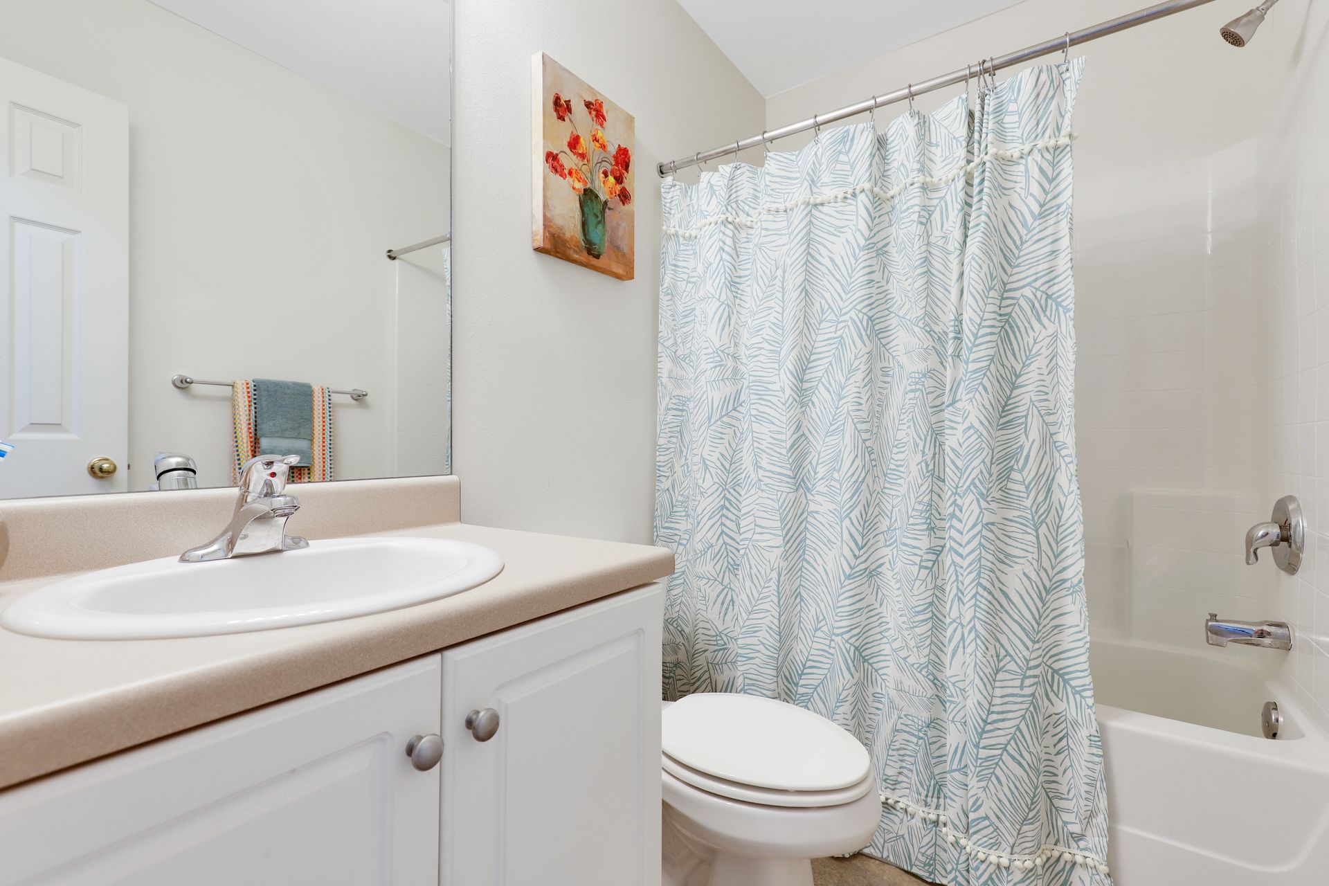 A bathroom with a sink , toilet , bathtub and shower curtain.